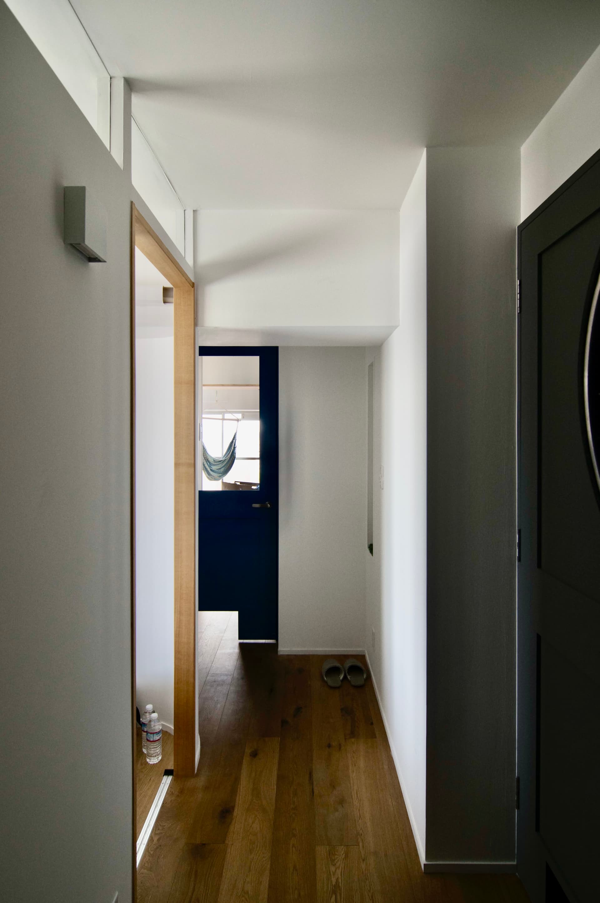 玄関から見た写真です。玄関を開けてリビングが丸見えにならないよう、ドアを正面からずらして設計しています。また、寝室と廊下の間の壁には室内窓があり、寝室からの光を廊下に取り込んでいます。