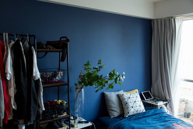 部屋A。ベランダに面した大きな窓があります。壁の一面だけネイビーになっています。