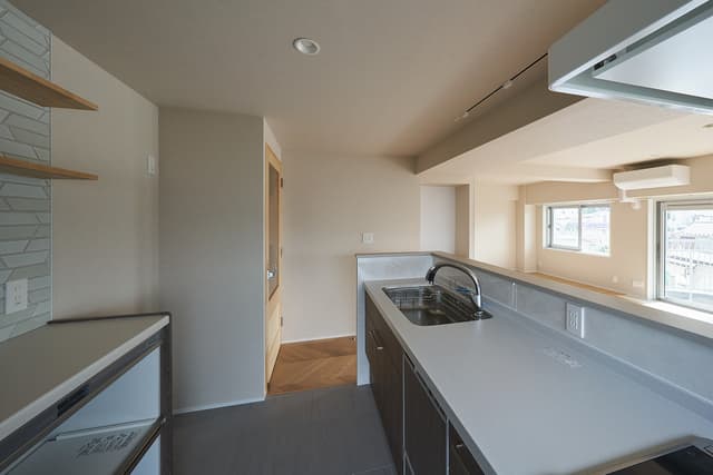 キッチンはフロアタイルに。夫婦で背が高いので、キッチンの高さは90cm、やや高めにしています。フロントオープン型の食洗機が付いています。