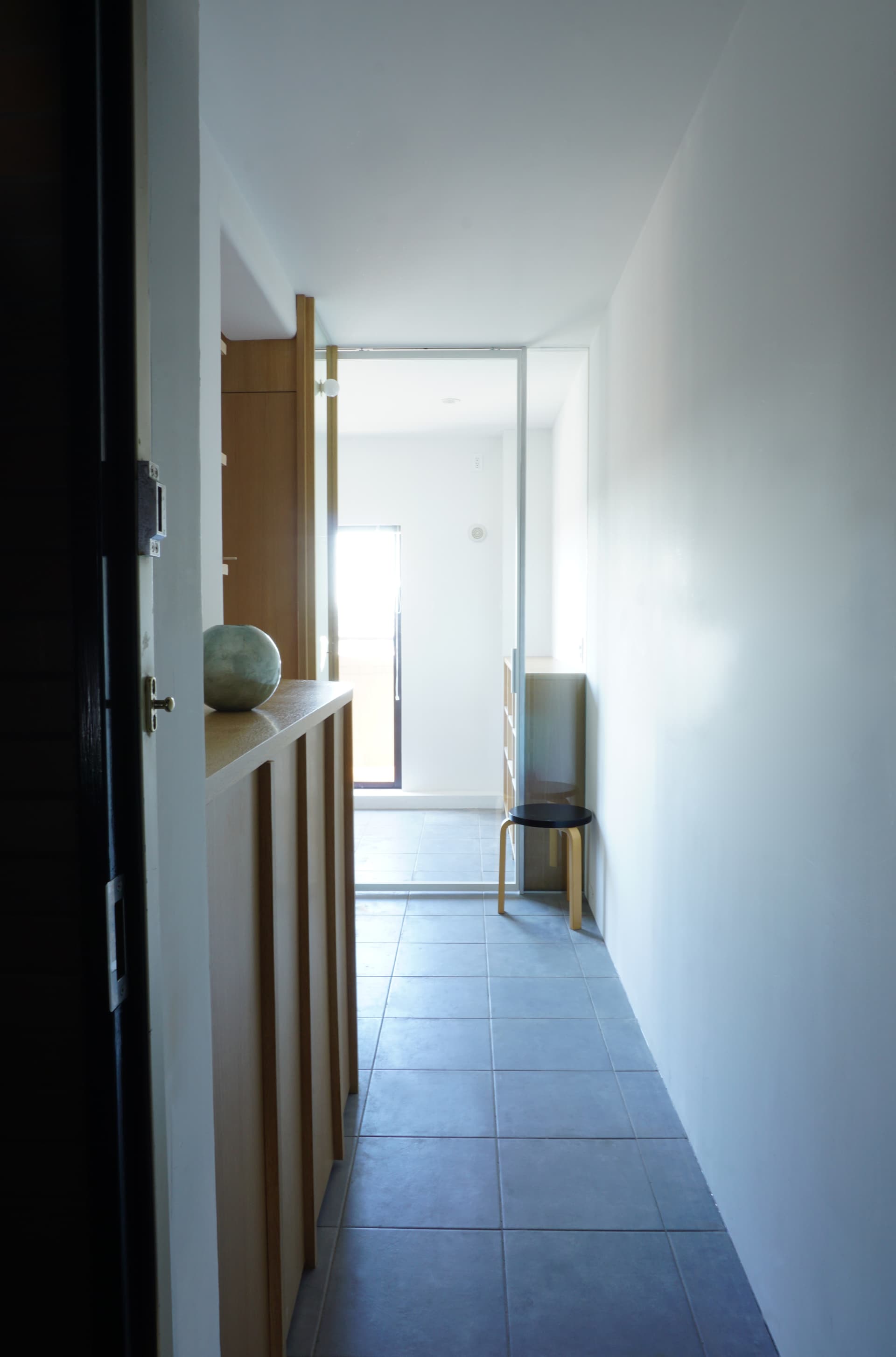 ワークスペースの建具をガラスにしたことで玄関を開けた瞬間にも明るい光が入るようにしました。ワークスペースとひとつながりの玄関とすることで玄関がとても広く余裕があるように見えます。