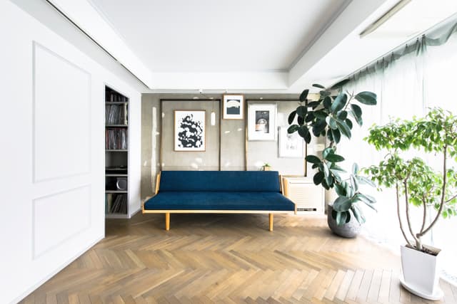 リビング。奥の壁は打ちっぱなし。当初は左の壁と同じく壁紙＋ウッドモールディングにする予定だったが施行中に打ちっぱなし＋真鍮モールディングに変更。左上は秘密基地的なミニ書斎。日当たりは抜群。