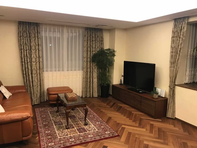 リビング　角部屋。フローリングはウォルナットのヘリンボーンです。天井は間接照明です。