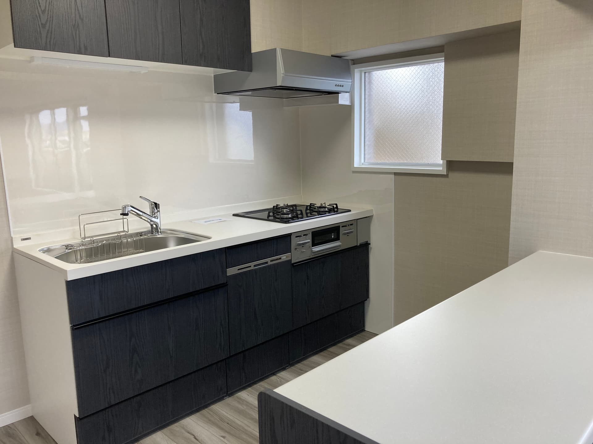 キッチン。Ⅱ型キッチンで作業スペースは大きいです。コンロは3口あり、食洗機も付いています。カウンターの下も収納になっており、非常に大容量です。