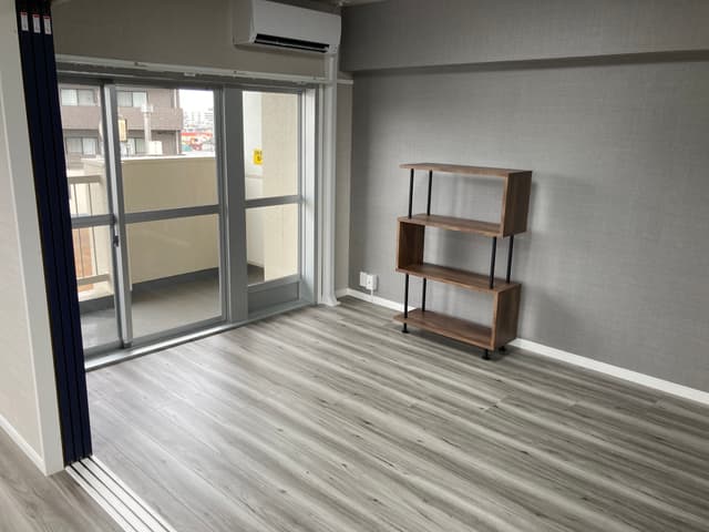 5.7畳の寝室です。こちらも眺望は抜けています。右側の壁のみグレーのアクセントクロスを使用しており、落ち着いた雰囲気です。ベッドを縦置きできる横幅があります。