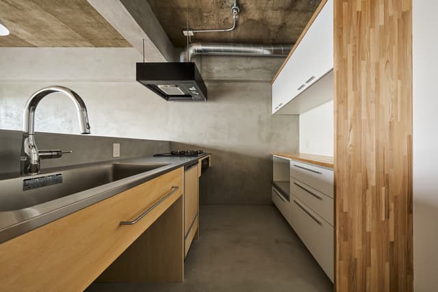 キッチン。作るところと作らないところ、造作と既製品を潔く使い分けています。シンク下にはキャスター付きゴミ箱がしっかり収まるサイズ感。
