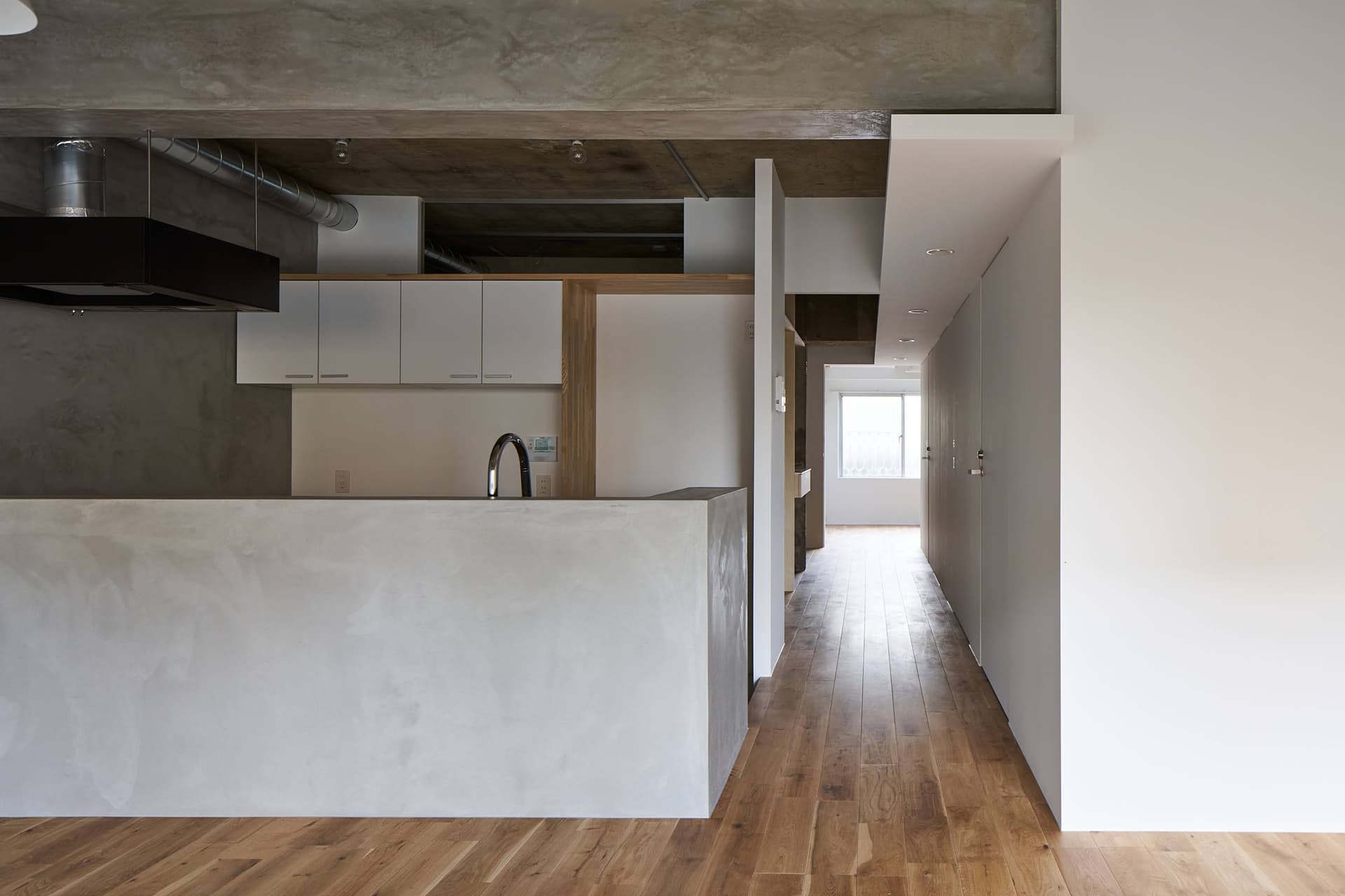 リビングから廊下を見る。すべてのドアが壁に収納できるので、11mの長さを生かした抜け間のある廊下を楽しめます。
