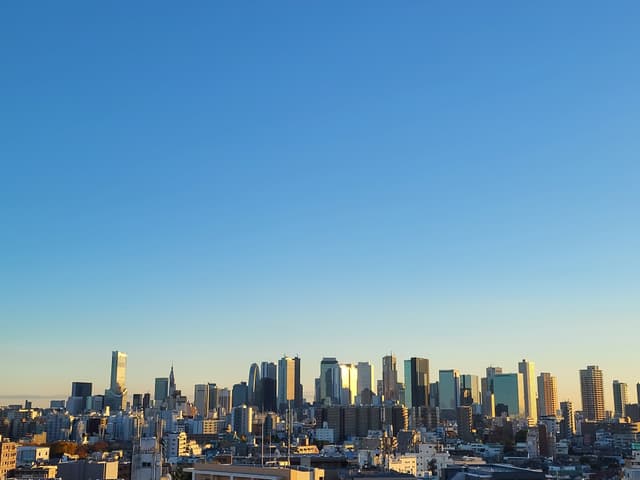 夕暮れ時の景色。部屋が南東向きなので夕日は見えませんが、太陽の光がビルに反射してとてもきれいです。共有部の屋上に上がると、夕日や富士山も見ることができます。