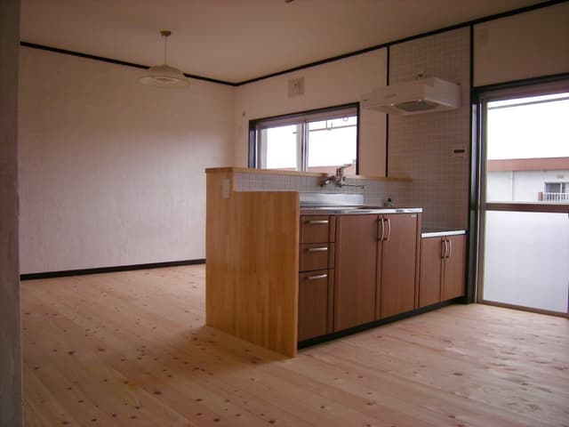 キッチン。
キッチンの向かいが和室でしたが壁を壊して一つの部屋になりました。部屋の真ん中にキッチンがあります。換気扇まわりの白いタイルが気に入っています。
腰壁の上(30x195cm)に炊飯器や電子レンジなどの家電を置くことができます。防水加工しております。横にコンセントも付いています。