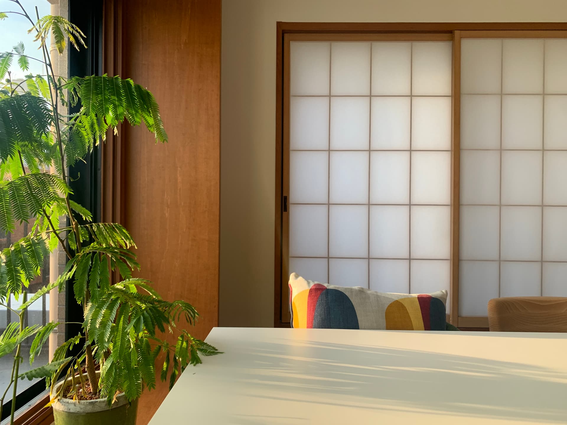 ダイニング: 障子と木目が夕日の中でモダンに調和する