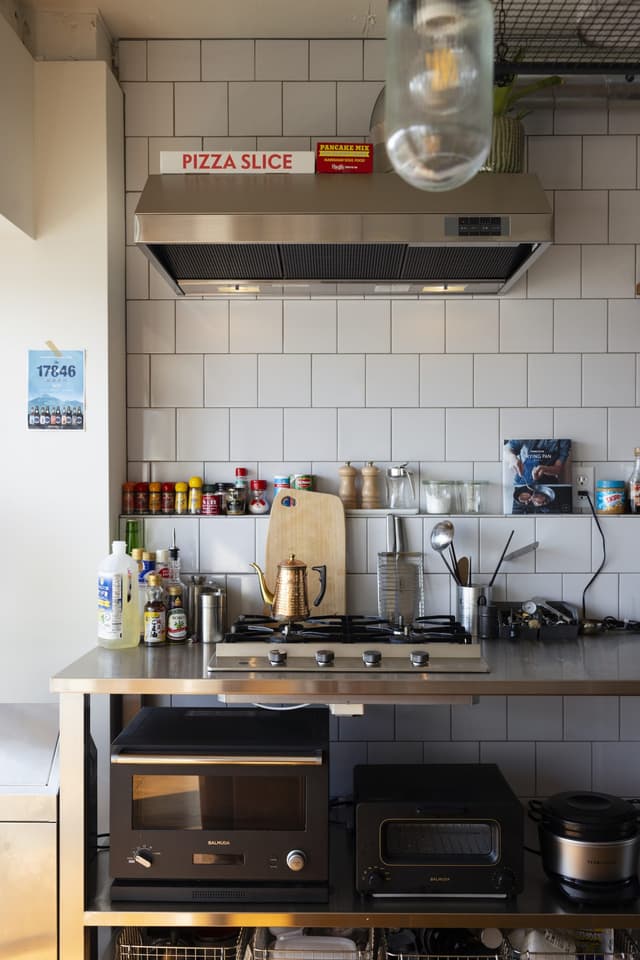 グレー目地のタイルはバスルームと同じタイルを同じ貼り方で施工しているため、浴室窓を通して見たバスルームとキッチンが一貫したルックスとなります。