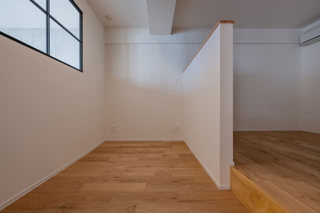 寝室兼ワークスペース。仕切りの左側のスペースに、デスクを置いて仕事をしています。左の窓から外が見れるので、閉塞感もなく時の流れを感じながら仕事ができます。
寝室は、仕切りがあるためワークスペースとの区切りができており気になりません。またリビングの明かりがついていても、仕切りのおかげで明るさは気にならずに寝られます。