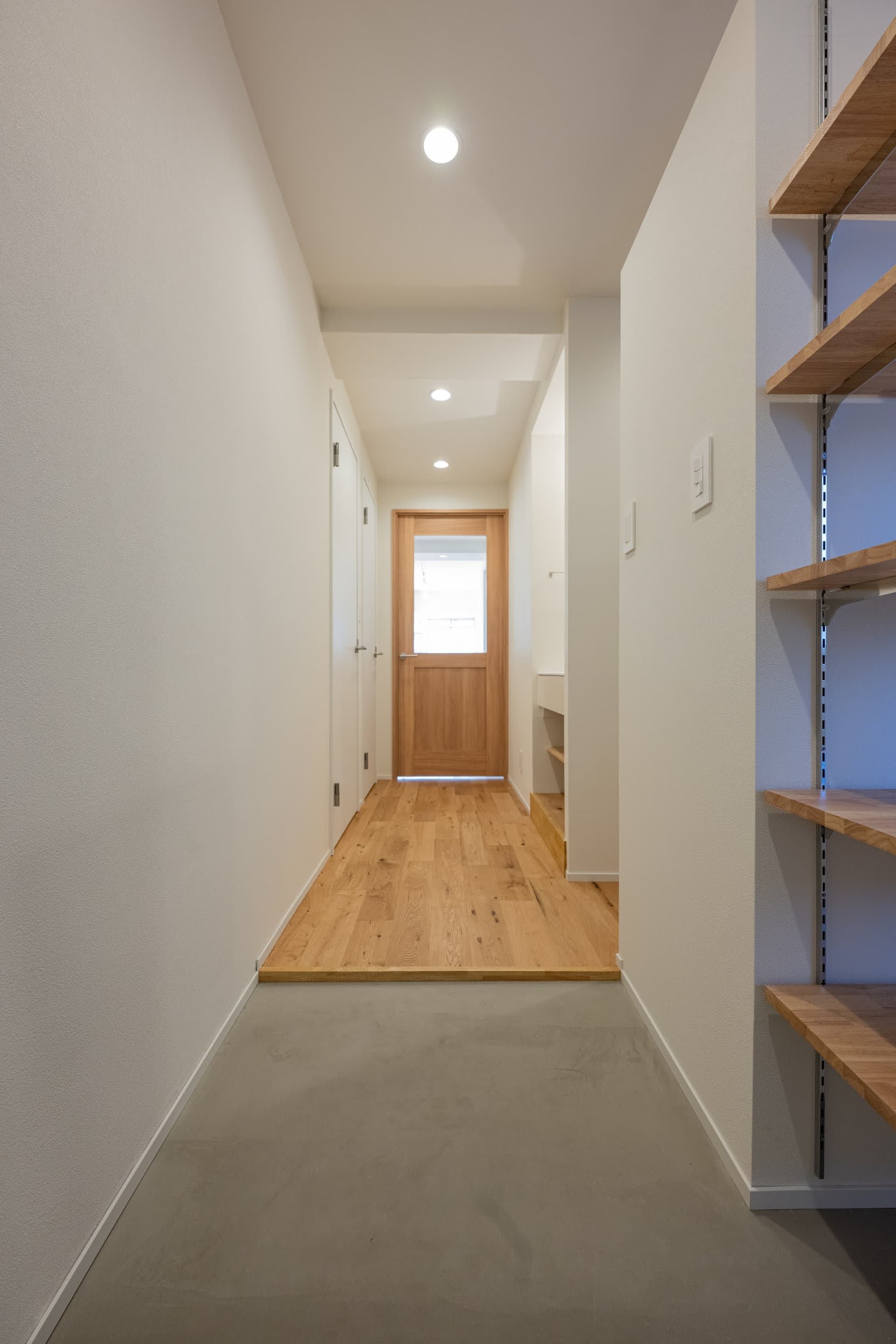 玄関入ってすぐ。土間部分を広くとっているので、大きな荷物を持ったり置いても、広々と使えます。正面のリビングへ繋がるドアはバルコニーからの光が抜けるように、設計しました。