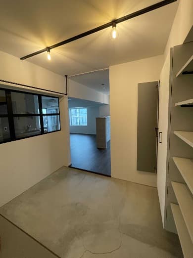 玄関を入ると室内窓つきの4帖ほどの土間があります。ワークスペースとして活用しています。室内窓の向こうはキッチンです。