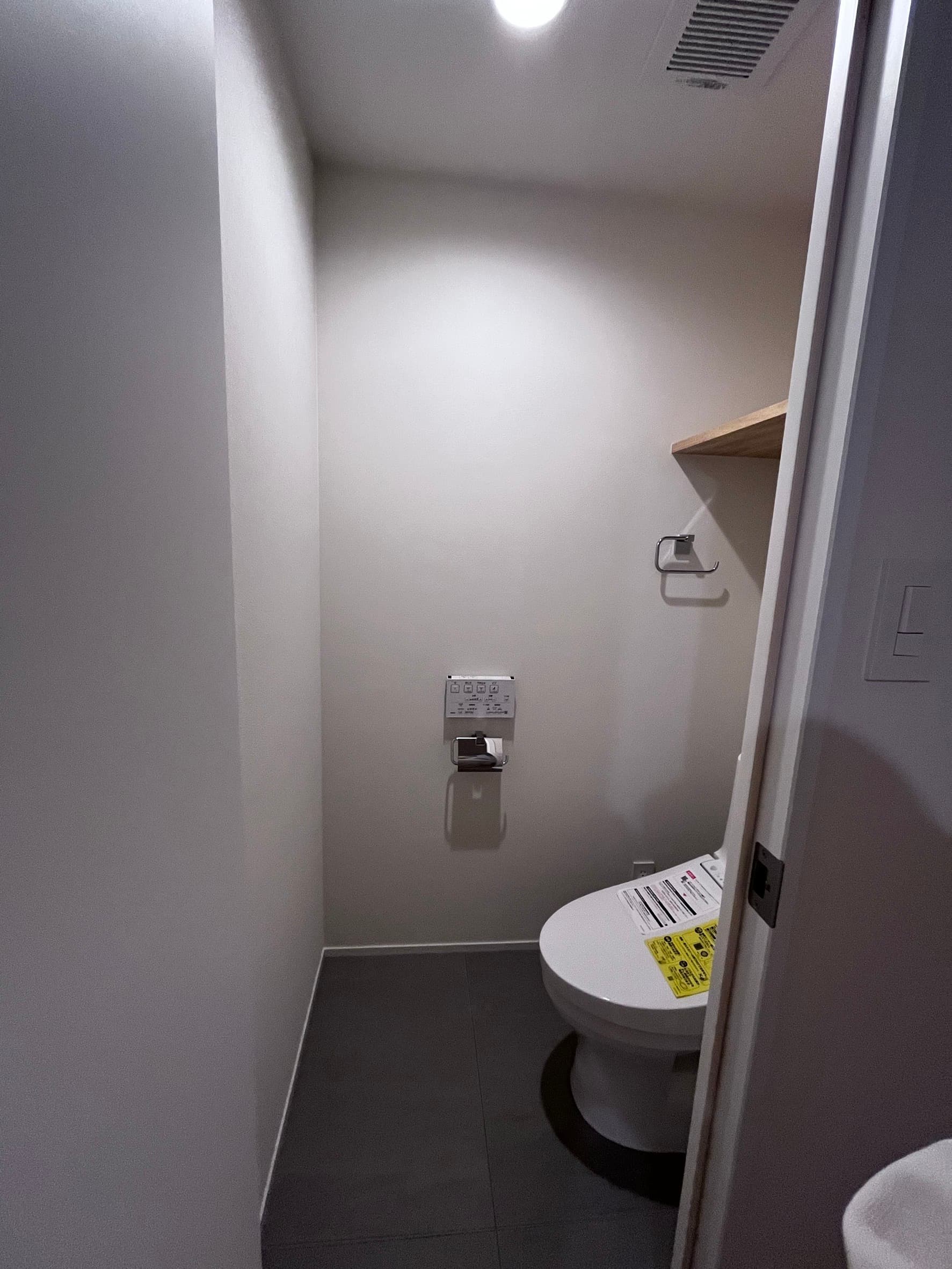 トイレ。床は汚れに強い塩ビタイルを利用。グレーベースの空間✖︎木材で落ち着いた環境です。