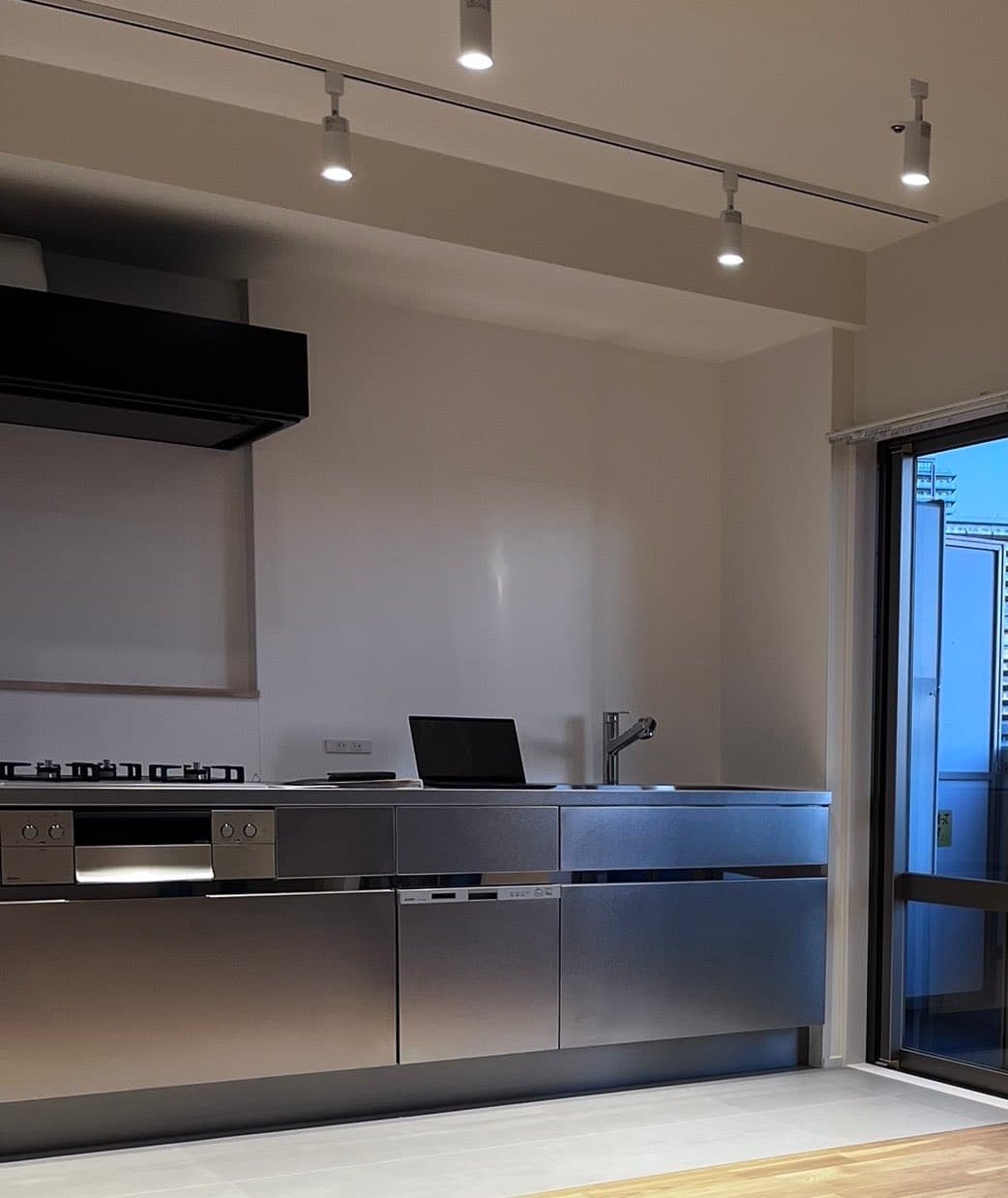 リビング(キッチン)。夜になるとスポットライトの当たり具合からオシャレな空間が一気に演出されたす。食洗機は6人用までのサイズ感なので、たくさん入ります。また、床は塩ビタイルで(水・油に強く)お掃除が楽に。デザイン性✖️機能性を最も重視。