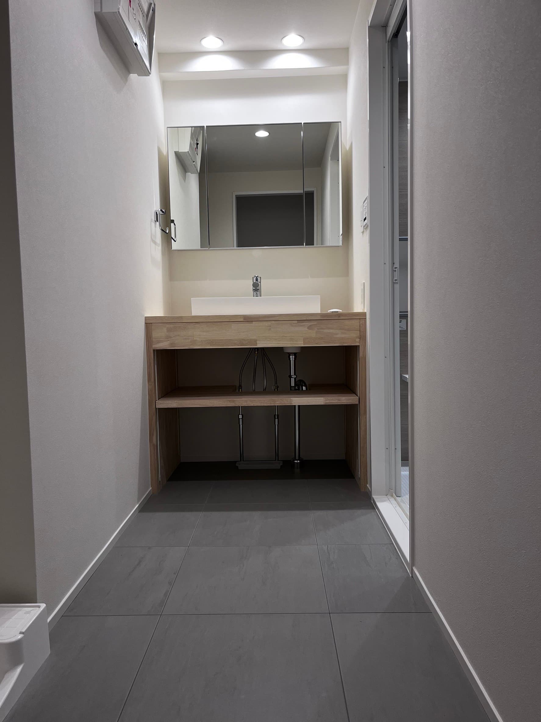 洗面台。塩ビタイルと木材の組み合わせで、スマートな空間に。収納を重視しており、見た目より洗面台は大きいです。大人2人が並べるくらい。洗面下はラテンの箱を置き収納として使っております。