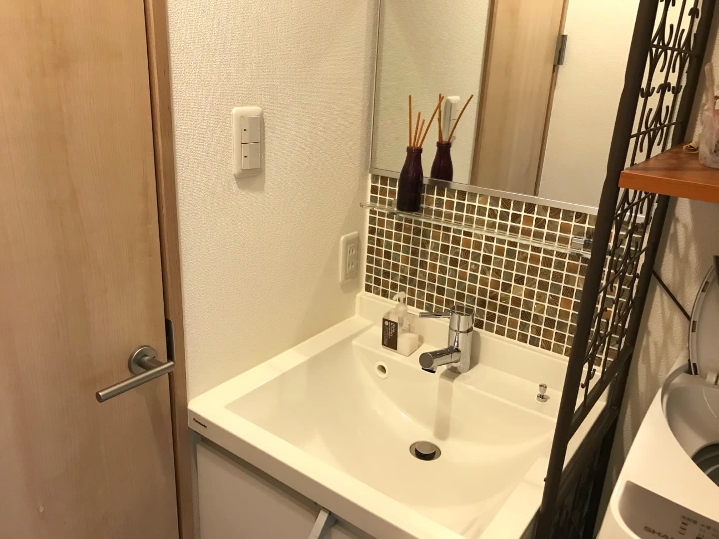 洗面所（脱衣室）。右側が洗濯機置き場、左の扉がトイレです。温水調節水栓。