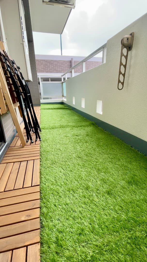 バルコニーはウッドパネルと人工芝を敷いてお庭風にアレンジ