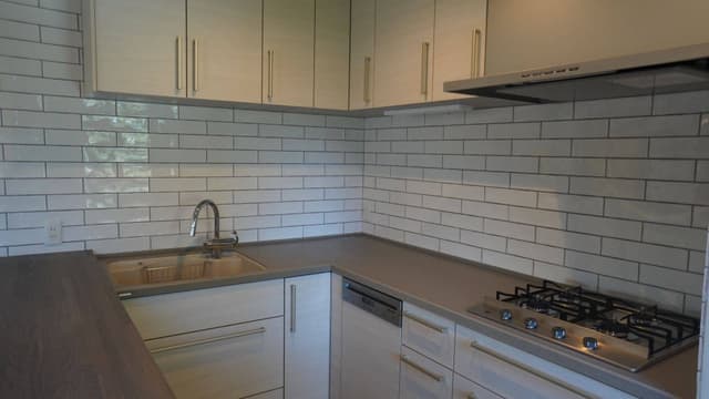 こだわりのキッチン。大きめの白タイル。キッチンはトクラスのコラージア、Milleの食洗機を内蔵。