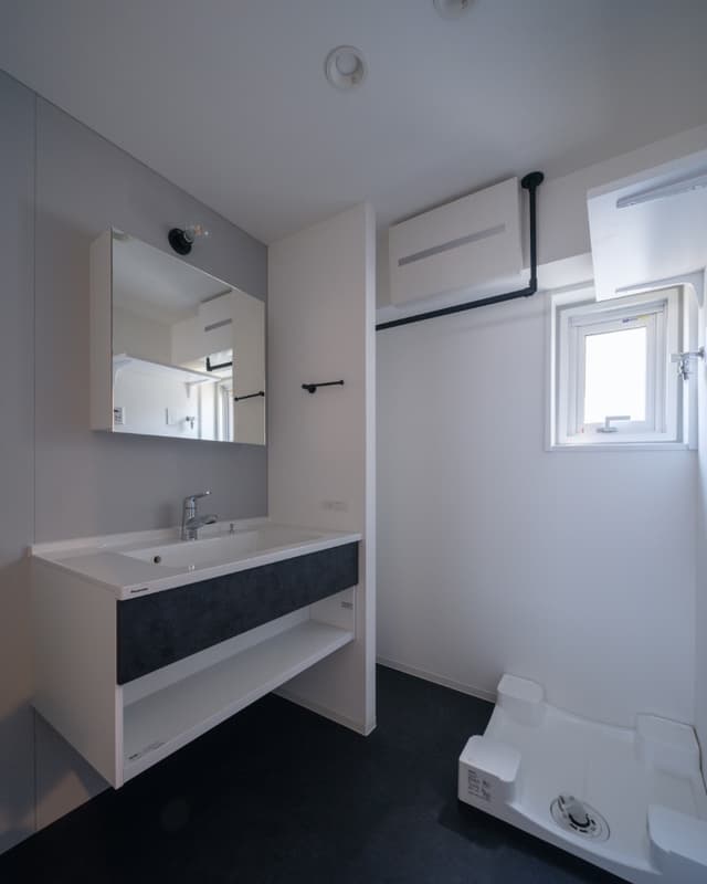 洗濯物を干せるアイアンバーも設置しています。洗面台横のふかした壁の奥に棚を置けばタオルなど収納ができ非常に便利です。