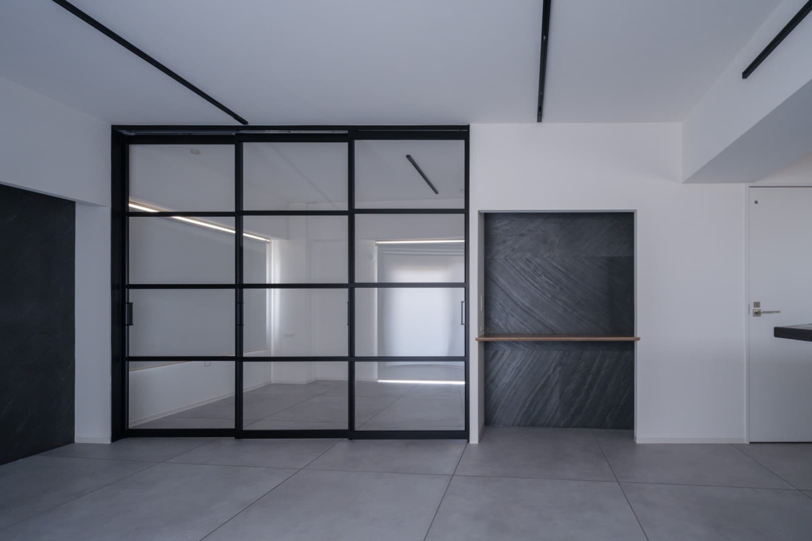 寝室との区切りは部屋が広く見えるように透明な引き戸で緩やかに区切っています。
寝室側の天井部には扉に沿ってカーテンレールを設置しているので必要に応じてカーテンで遮光や目隠しをすることも可能です。