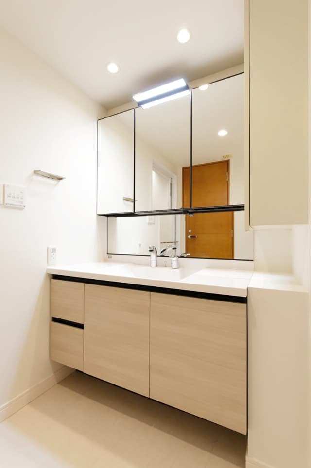 洗面台。大きなミラーとカウンターが特徴の洗面台で、朝の身支度やスキンケアもゆったり行えます。収納スペースがしっかり確保されているため、洗面用品やタオル類もすっきり片付きます。