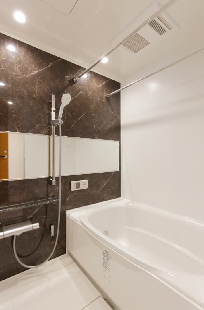 お風呂。落ち着いたカラーのパネルを採用したバスルームで、一日の疲れをゆっくり癒せる空間です。浴槽は足を伸ばして浸かれるサイズ感で、バスタイムをより快適にしてくれます。お手入れのしやすさにも配慮された設備です。