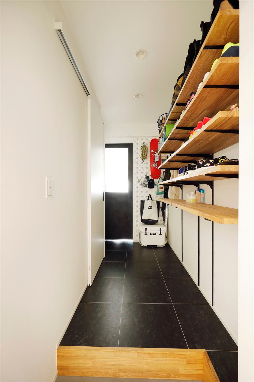 玄関の土間（？）スペースは有孔ボードと造作の可動棚でアウトドアグッズを置いたり趣味のコーナー