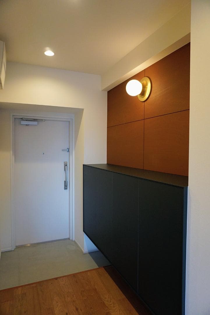 玄関扉は2024年にマンション全体で刷新済み。下駄箱も大きく、ブラケットライトが可愛くてお気に入りです。
