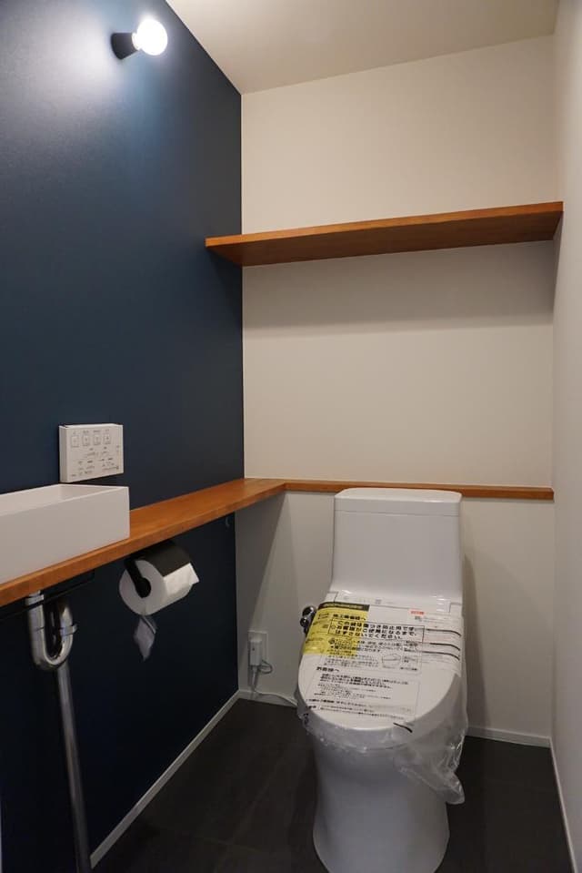 お手洗いにはアクセントカラーの壁紙も。ウォシュレット機能付き。