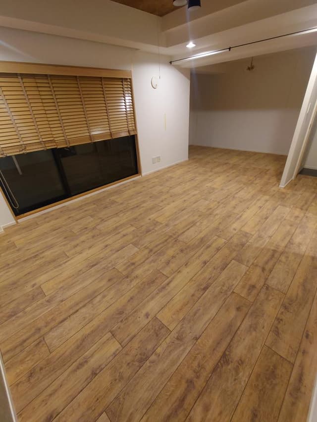 リビングです。壁を取りはらい、必要に応じてカーテンで仕切れるよう梁にレールをつけています。床はペットのために木目調のパイルカーペットを敷いていますが、下は黒のフローリングです。