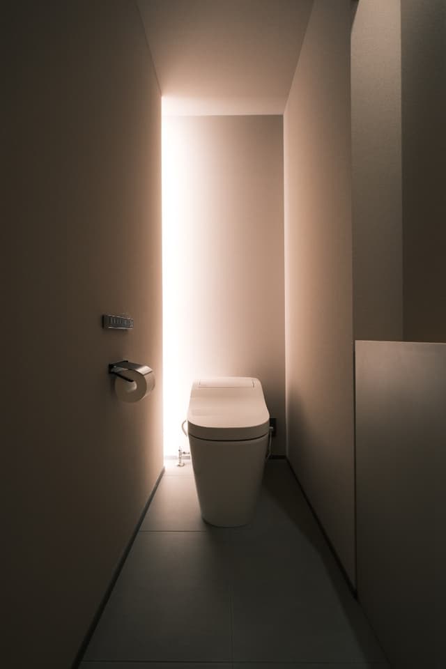 トイレ
ホテルライクなトイレを目指してデザインしました。落ち着いた雰囲気の空間としています。右側の収納棚には小さいですが掃除道具やトイレットペーパーのストックを収納しています。