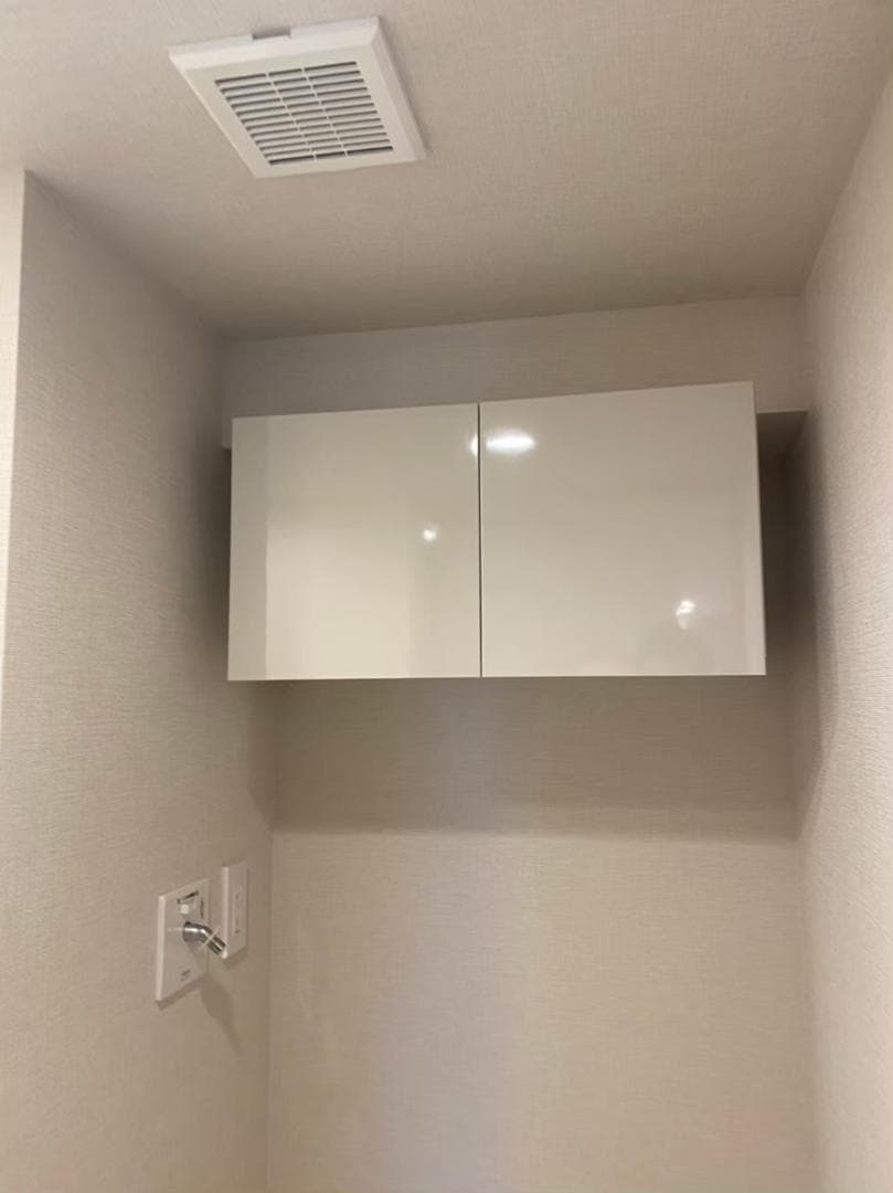 洗濯機上には分譲時のオプションで吊戸棚を設置しており、デッドスペースになりがちな空間を有効活用できます。洗剤やストック類をすっきり収納でき、生活感を抑えながら整った空間を保てる点が気に入っています。（入居前写真）