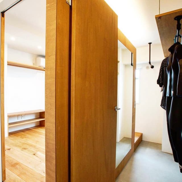 右手はウォークスルークローゼットには大きな姿見があり、靴を履いたまま出かける前の身だしなみチェックが可能。来客時にはドアを閉めて隠すことができる。
左手は約8畳のベッドルーム。可動式のテレビ台があり、ホテルライクな寝室を作ることが可能。