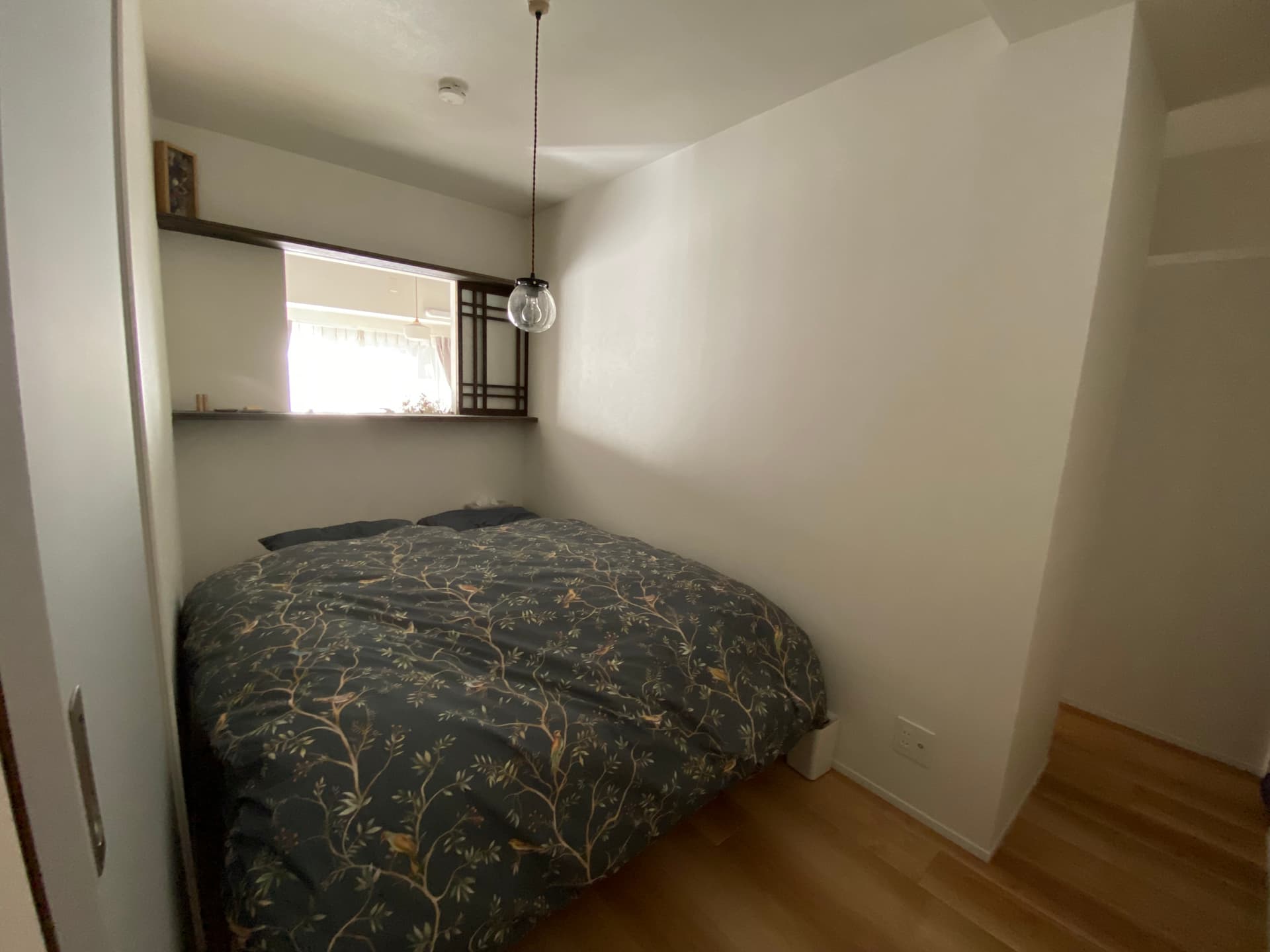 寝室はクイーンサイズのベッドと左右10cmほどのぴったりサイズで作っています。
内窓の上下に飾り棚があり、小物や本を置くのに便利です。