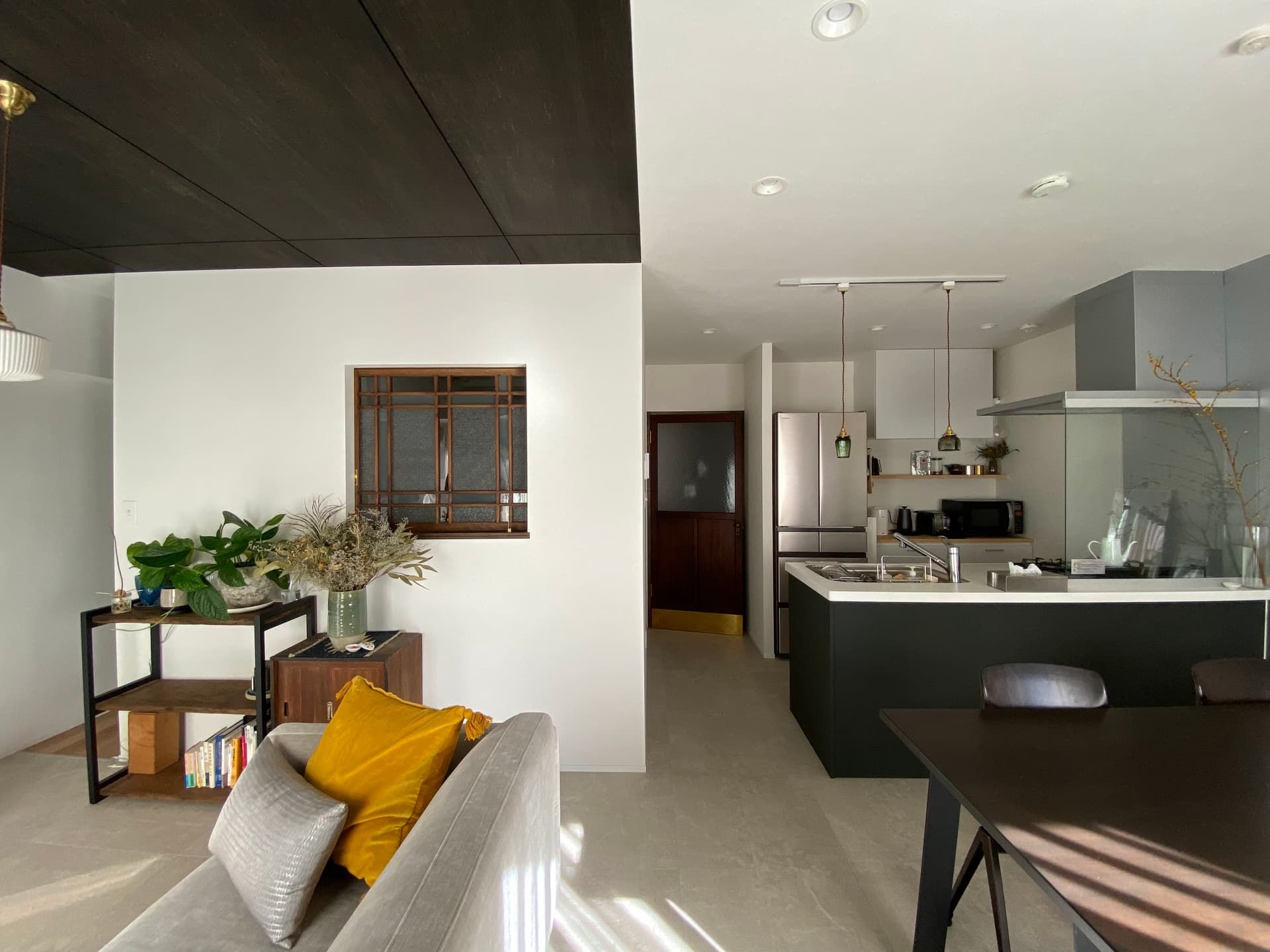 約18畳のLDK。
グレーのタイル調の床材は、モダンテイストのインテリアとよく合い、汚れづらく手入れもしやすいです。
リビングドアは明治期のもので真鍮を足しています。