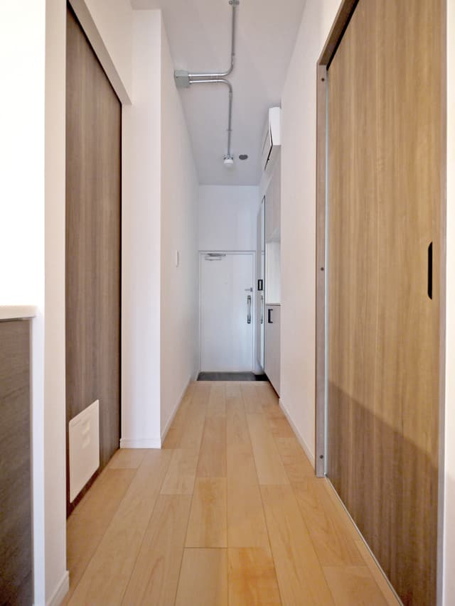 廊下です。
手前が水回り、奥が寝室です。
広く見えるよう抜け感を大事にし、リビングドアはつけていません。