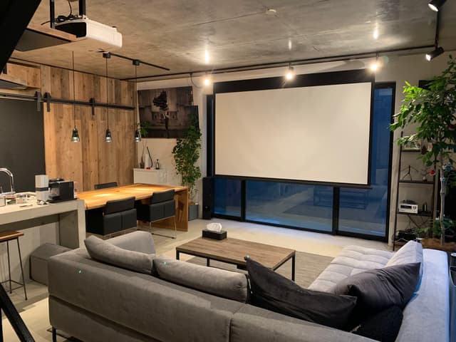 リビング。角部屋なので2面採光
こちらB1でドライエリア外側からの視界がないのでカーテンなしで快適に過ごせます

天井高2.75mなので、面積以上に解放感を感じられます。

テレビやゲーム、ネット番組はプロジェクターで大画面で見れるので、友人が来ると盛り上がります！

B1フロアは床が全面モルタルでインダストリアルな感じ（床暖あるのでご安心ください）