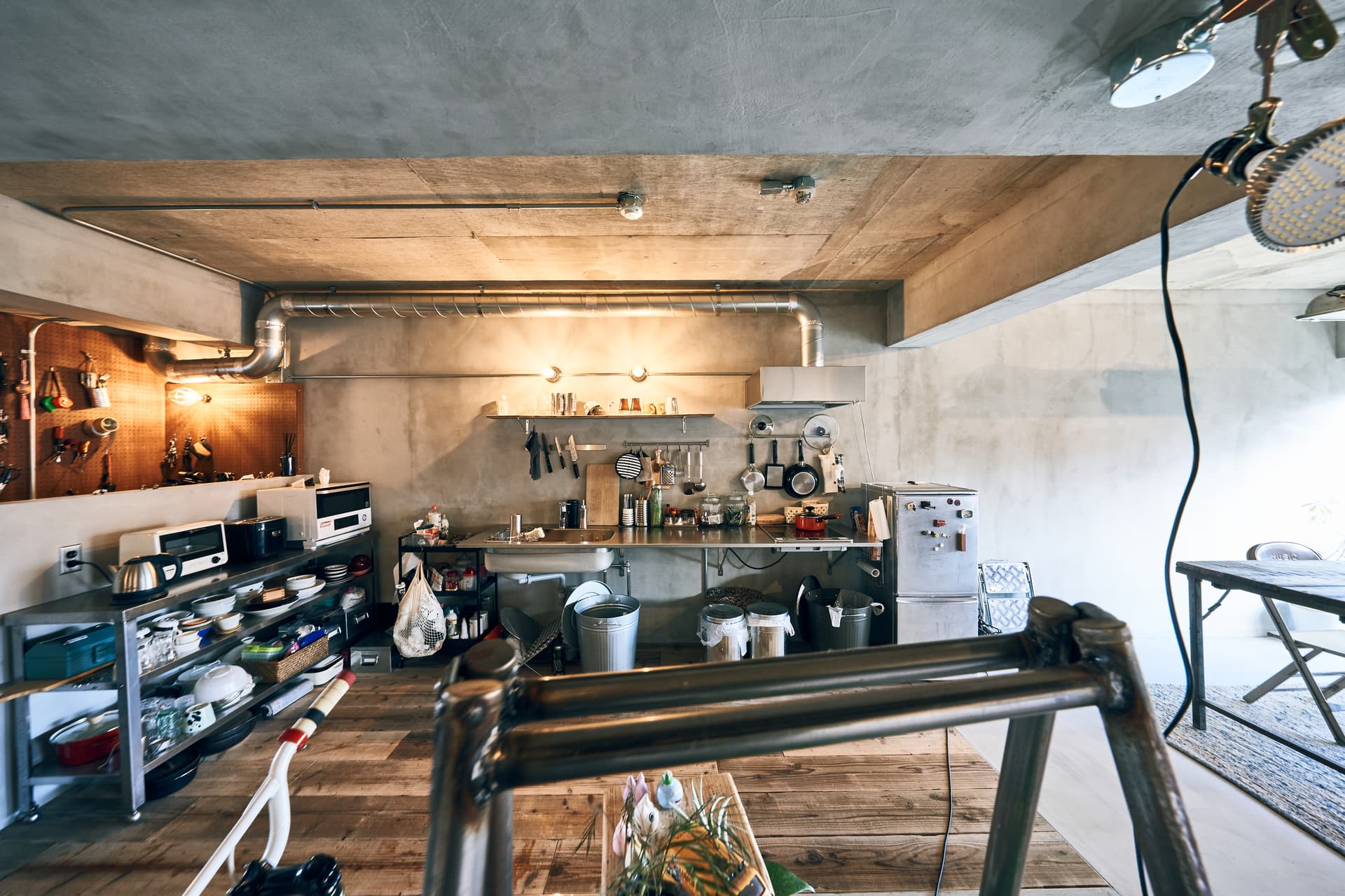 キッチンは壁付けです。シルバーで揃えました。床は古い足場板です。