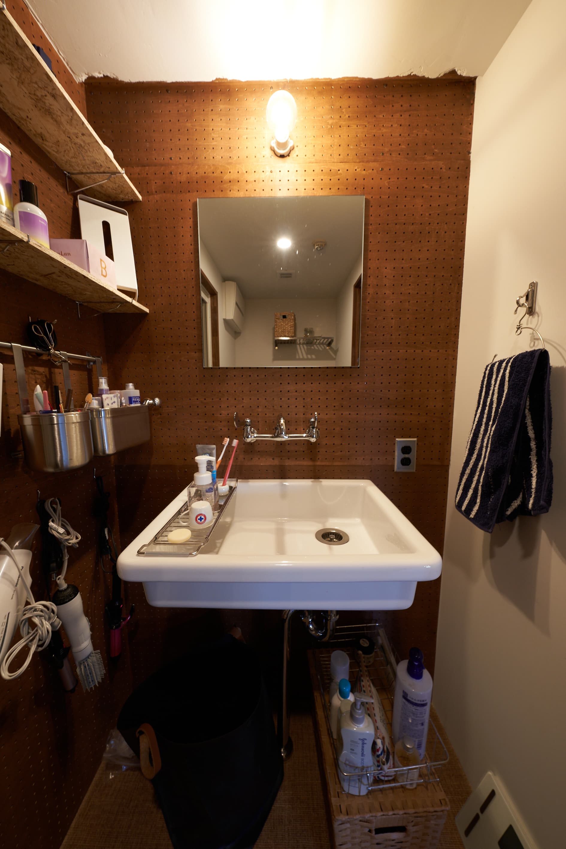 洗面はいろんなものを掛けられるようにパンチングボードにしました。実験用のシンクで大きなものにしています。蛇口もイメージを揃えました。明るく湿気ぽくなくしたくて、壁や天井は白くしています。生活感があってすみません・・・