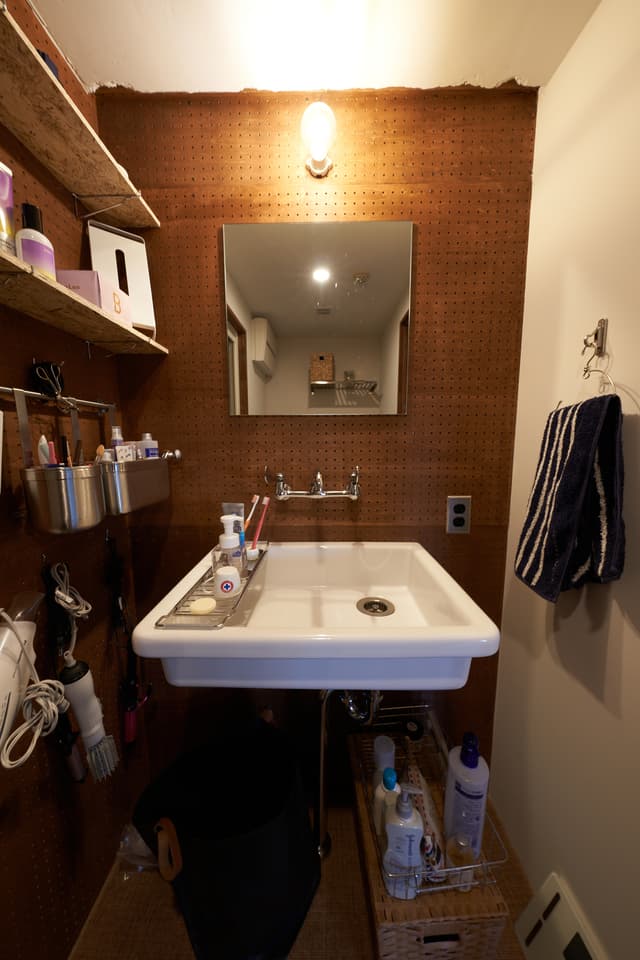 洗面はいろんなものを掛けられるようにパンチングボードにしました。実験用のシンクで大きなものにしています。蛇口もイメージを揃えました。明るく湿気ぽくなくしたくて、壁や天井は白くしています。生活感があってすみません・・・