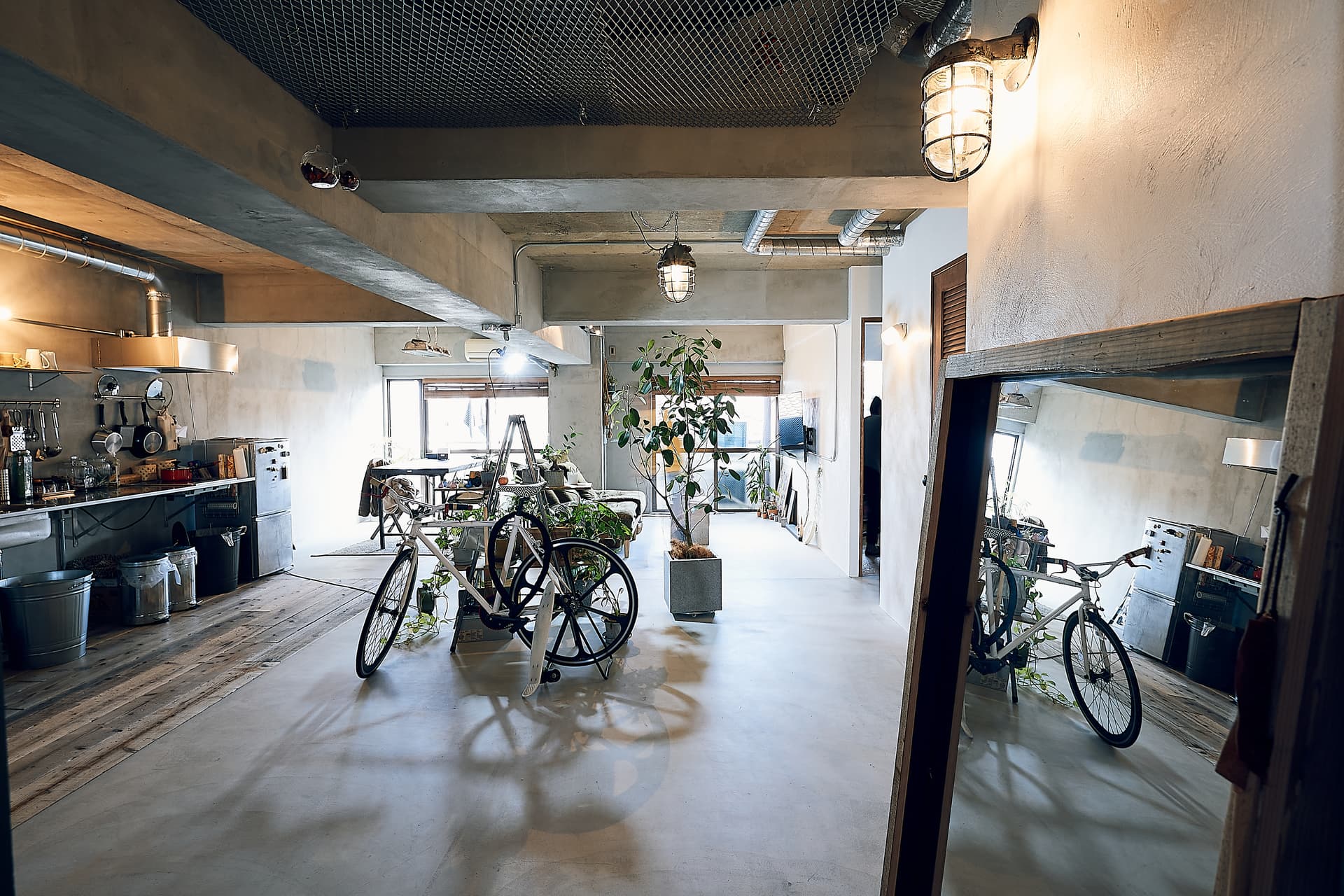 玄関からです。床はモルタル、キッチンのエリアは古い足場板を敷いています。天井はコンクリ現しです。