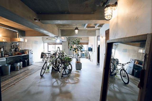 玄関からです。床はモルタル、キッチンのエリアは古い足場板を敷いています。天井はコンクリ現しです。