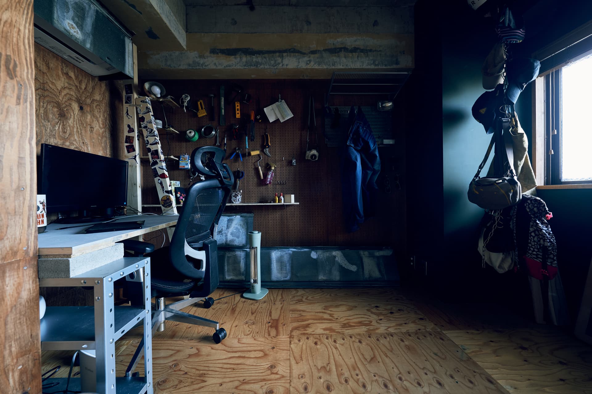 玄関から入って右側の部屋です。仕事スペースとして使っています。床はラワン材で市松模様のように木材の向きを変えています。正面の壁はパンチングボード、左側は床と同様にラワン材、右側は濃い緑色です。
